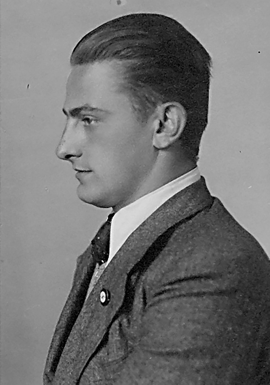 Profilaufnahme eines jungen Mannes mit Anzug und Hakenkreuz-Pinnadel. &copy; Deutsches Bundesarchiv