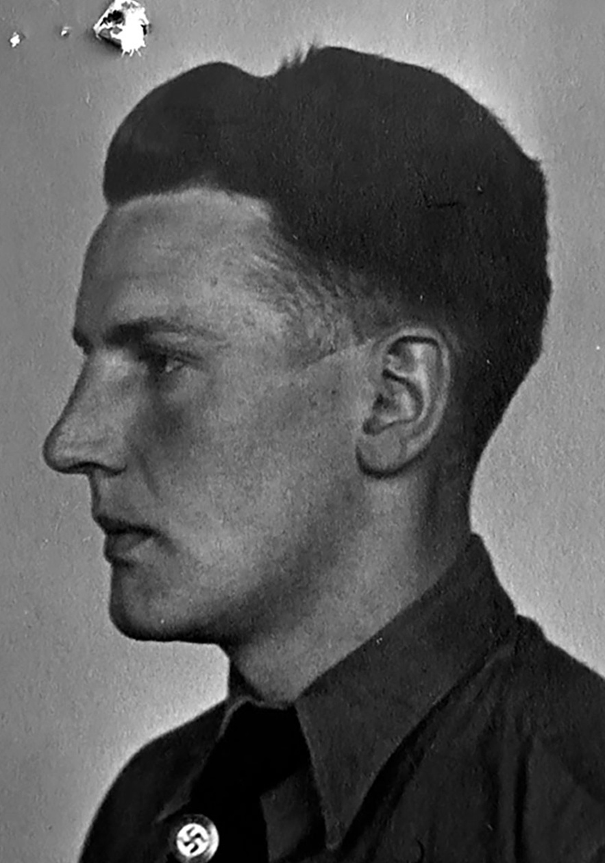 Profil eines jungen Mannes in Hemd, Krawatte und darauf Hakenkreuz-Pinnadel. &copy; Deutsches Bundesarchiv