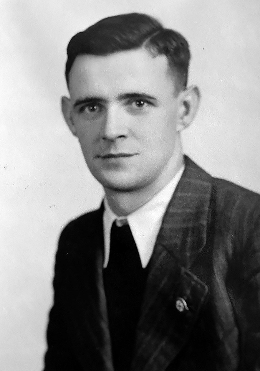 Halbprofil von Mann mit Nadelstreifenanzug, wei&szlig;em Hemd, dunkler Krawatte und Hakenkreuz Pinnadel am Revers. Blickt in die Kamera &copy; Deutsches Bundesarchiv