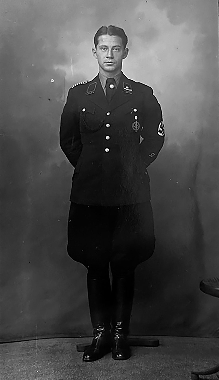 Totale von Mann in schwarzer Uniform. Gl&auml;nzende Lederstiefel, Hakenkreuzbinde am linkem Arm, unter dem Krawattenknoten Hakenkreuz-Pinnadel. Blick zur Kamera &copy; Deutsches Bundearchiv