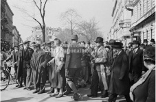Eine Menschenmenge, einige tragen Hakenkreuz-Armbinden, treibt mindestens drei Juden vor sich her. Im Hintergrund H&auml;user und B&auml;ume. &copy; &Ouml;NB Bildarchiv 