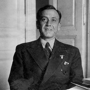 Mann mit Anzug, doppelreihige Konpfleiwte, Einstecktuch, nicht erkennbare Pinnadel am Revers, gestreifte Krawatte, helles, eventuell gestreiftes Hemd. Im HIntergrund eine offene, hell lackierte Holzt&uuml;r. &copy; &Ouml;StA / StiKo, Zl. 19 PA Blau